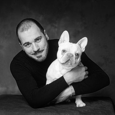 Black and white Portrait of a man dressed in a black top with his white French Bulldog by PHOTOGENIC Dalkey