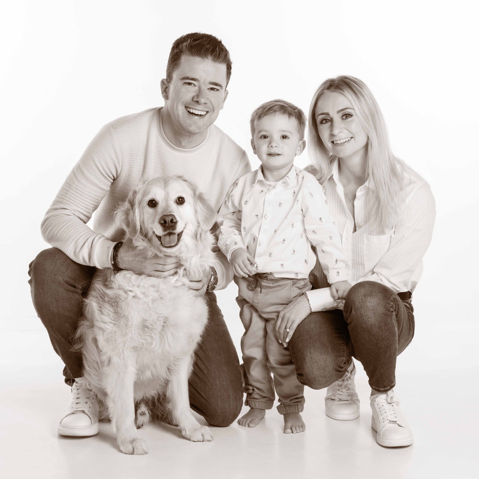 Black and white family photo with a child and dog on a white background