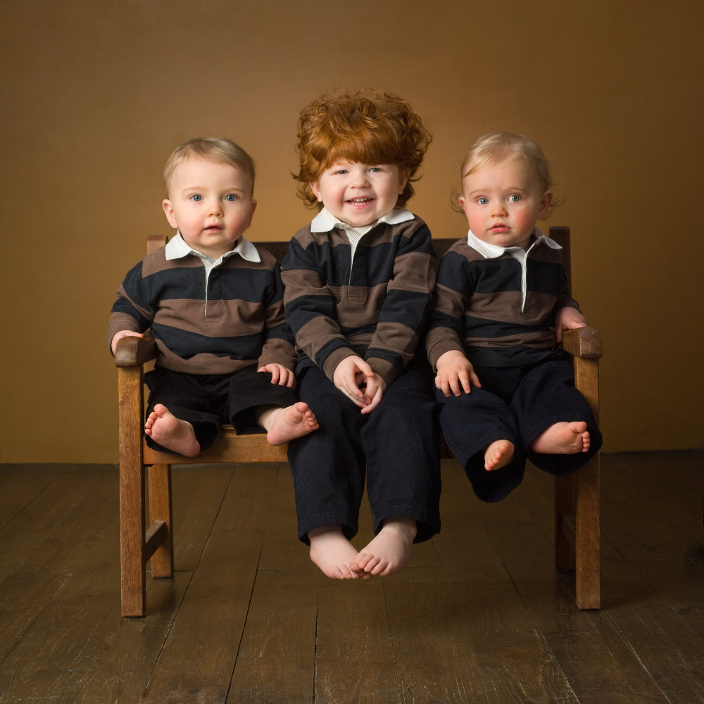 Colour Portrait of three young children dressed in dark clothes on a dark background by PHOTOGENIC Dalkey