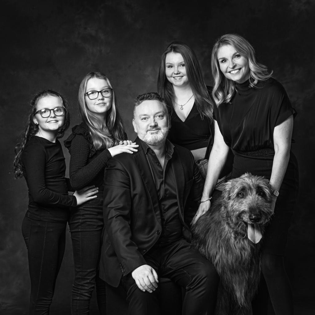 Black & white portrait of a family of 3 daughters & 2 parents with an Irish Wolfhound