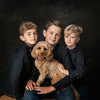 Portrait in colour of three little boys and their small golden Cockapoo dog