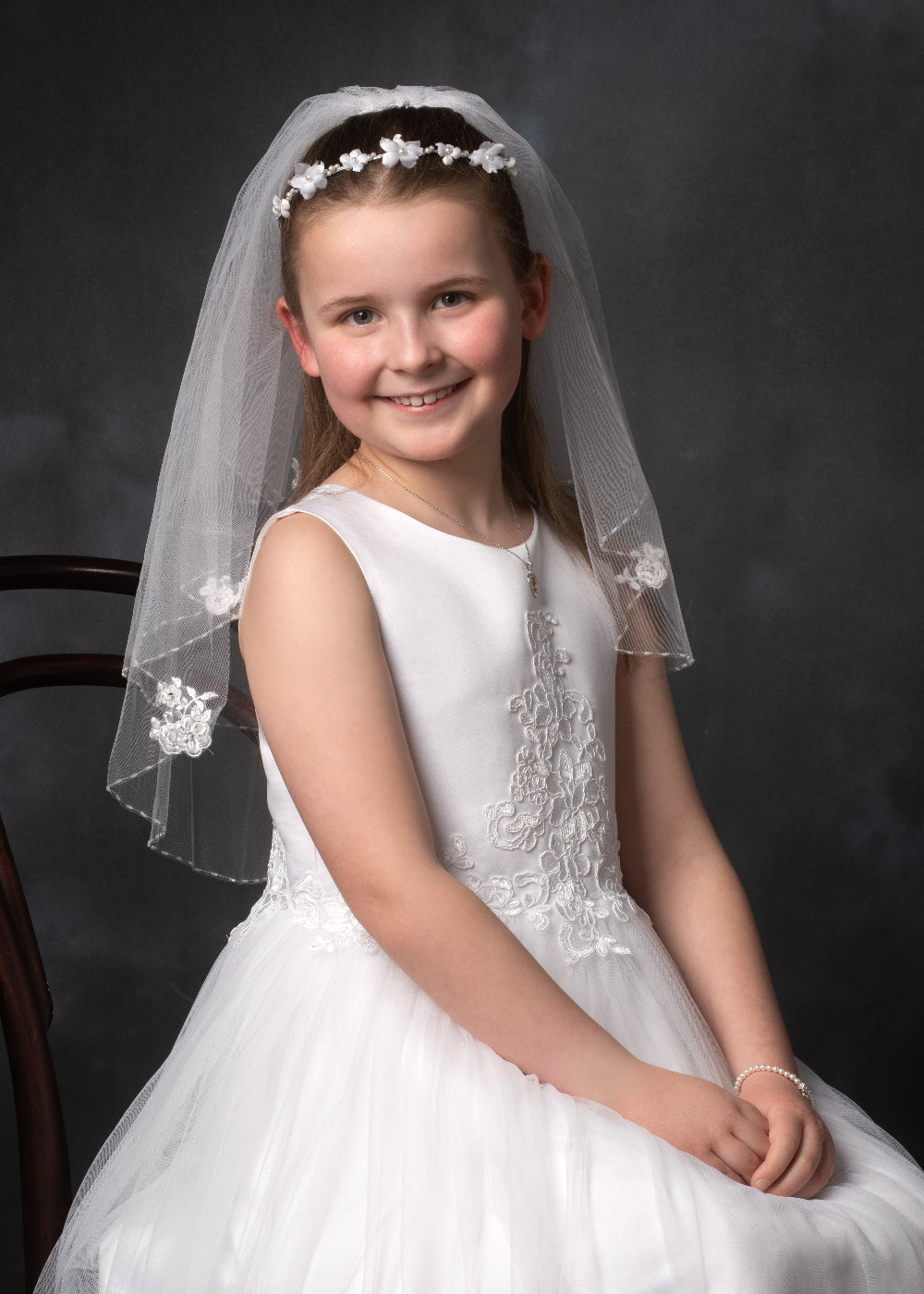 Communion portrait in colour  of a girl on a dark background by PHOTOGENIC Photographers