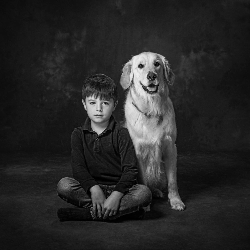 Portrait in black and white of a little boy and his golden Retriever dog sitting side by side  PHOTOGENIC Dalkey